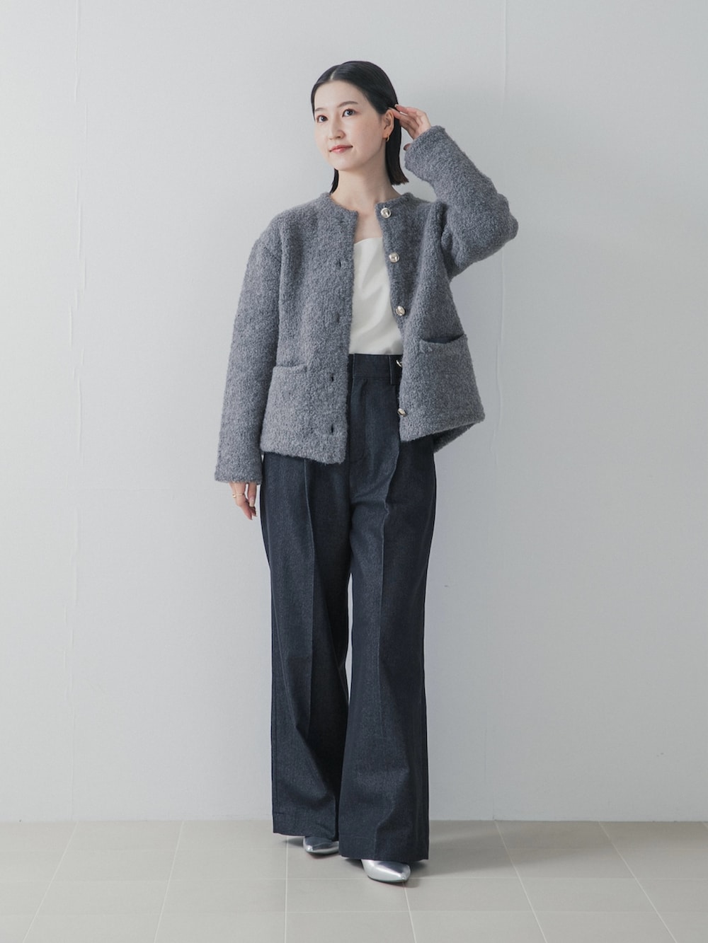 ブルー系のデニムパンツ、シルバー系のパンプス、グレー系のノーカラージャケットを着用したレディースの秋コーディネートの3枚目の写真