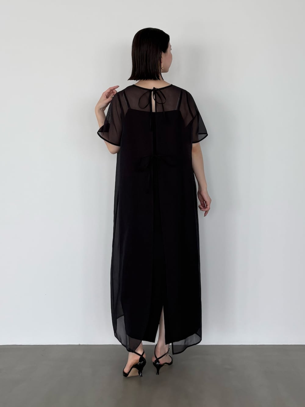 ブラック系のワンピースを着用したレディースの春コーディネートの3枚目の写真