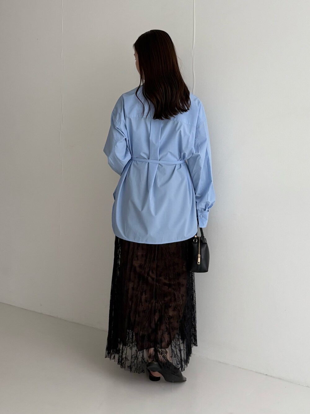 ブルー系のシャツ/ブラウス、ブラック系のスカートを着用したレディースの秋コーディネートの3枚目の写真