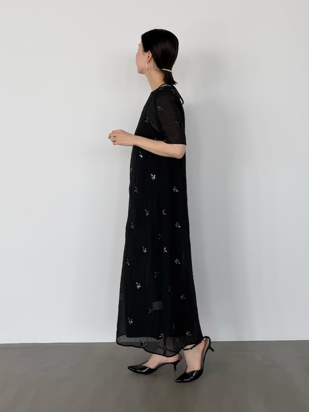 ブラック系のワンピースを着用したレディースの春コーディネートの3枚目の写真