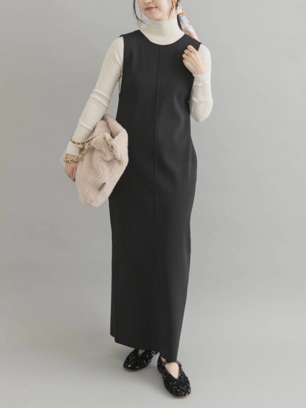 ホワイト系のショルダーバッグ、ブラック系のパンプス、ブラック系のワンピースを着用したレディースの秋コーディネートの4枚目の写真