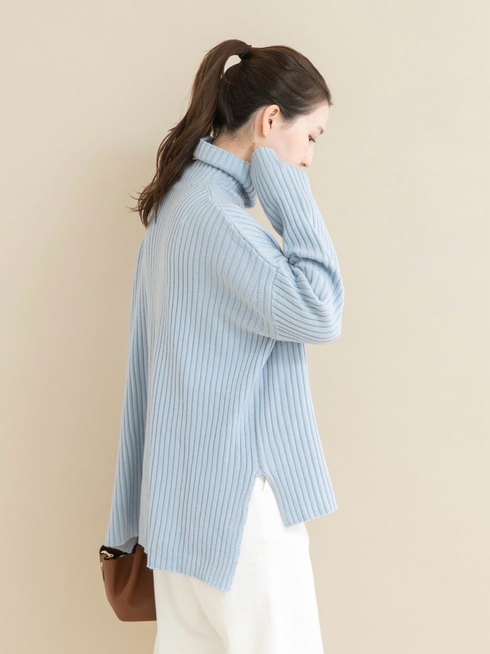 ブルー系のニット/セーター、ホワイト系のデニムパンツを着用したレディースの冬コーディネートの4枚目の写真