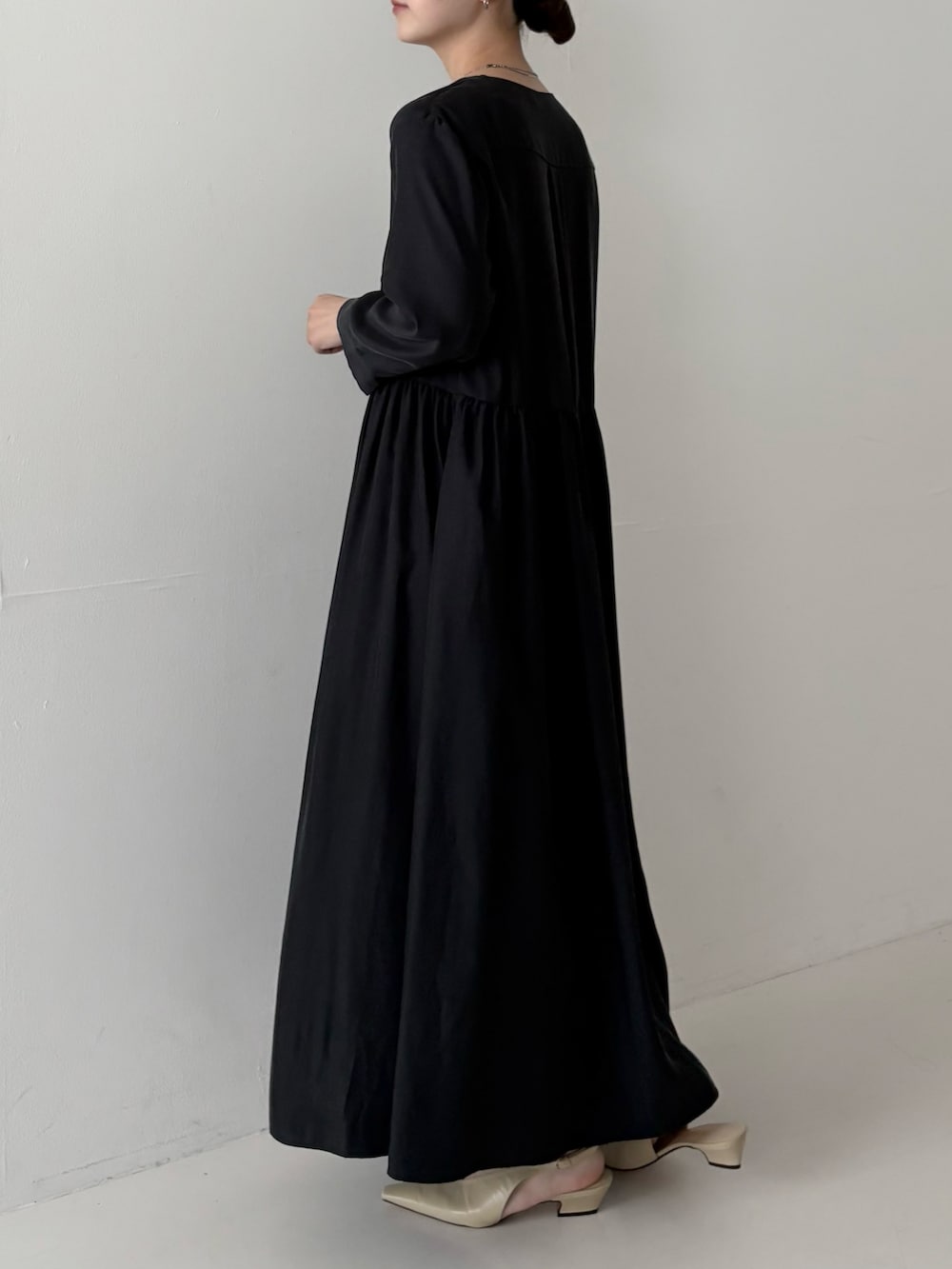 ブラック系のワンピースを着用したレディースの夏コーディネートの2枚目の写真