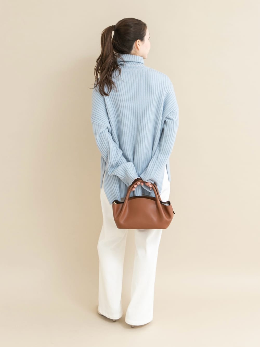 ブルー系のニット/セーター、ホワイト系のデニムパンツを着用したレディースの冬コーディネートの2枚目の写真