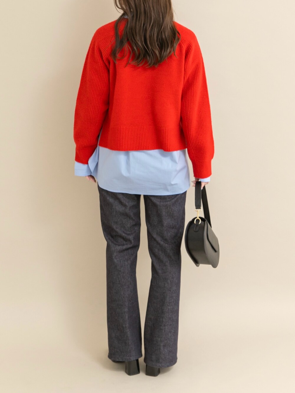 レッド系のニット/セーター、ブラック系のパンプスを着用したレディースの冬コーディネートの3枚目の写真