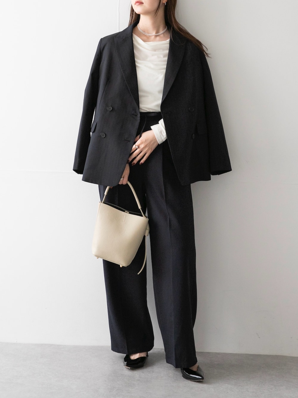 ベージュ系のハンドバッグ、ブルー系のその他パンツ、ブルー系のその他アウターを着用したレディースの秋コーディネートの2枚目の写真