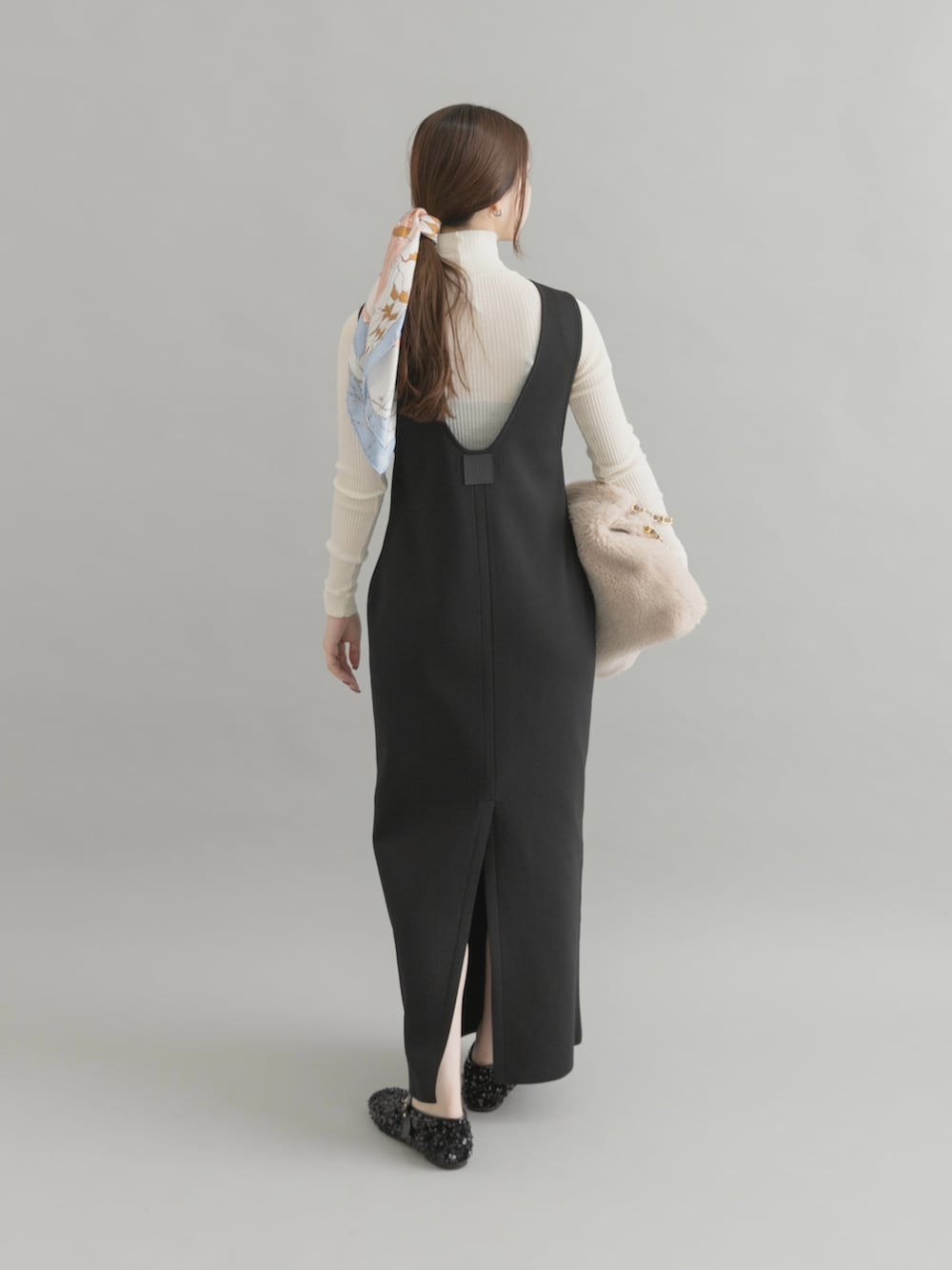 ホワイト系のショルダーバッグ、ブラック系のパンプス、ブラック系のワンピースを着用したレディースの秋コーディネートの3枚目の写真