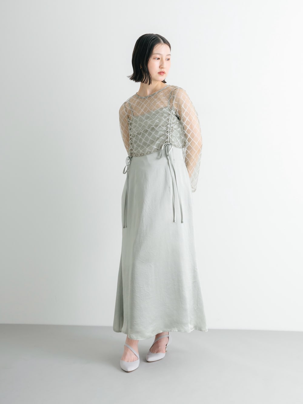 グレー系のパンプス、グリーン系のワンピースを着用したレディースの夏コーディネートの2枚目の写真