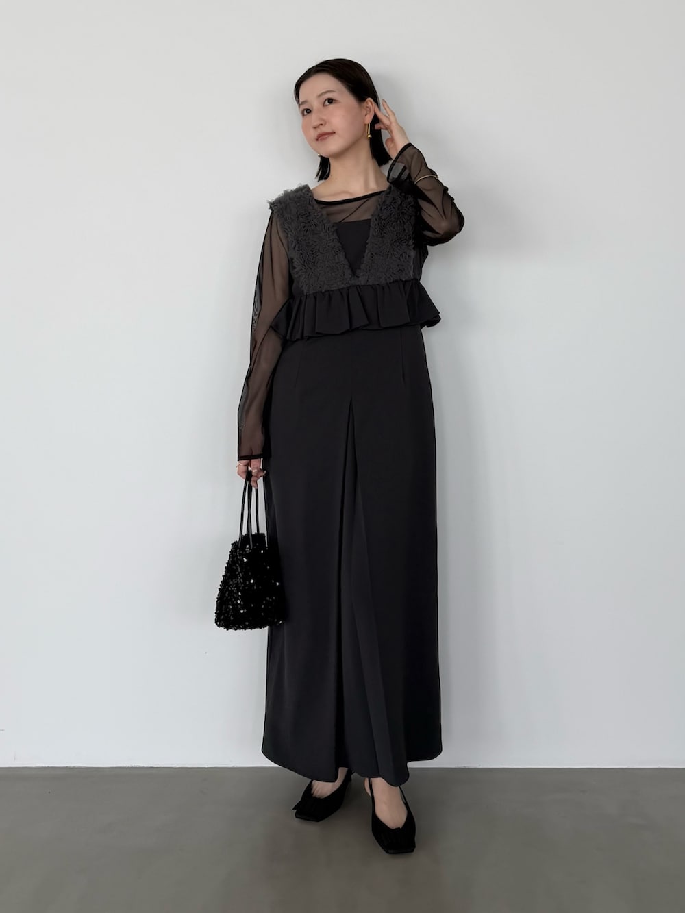 グレー系のワンピース、ブラック系のパンプスを着用したレディースの冬コーディネートの2枚目の写真