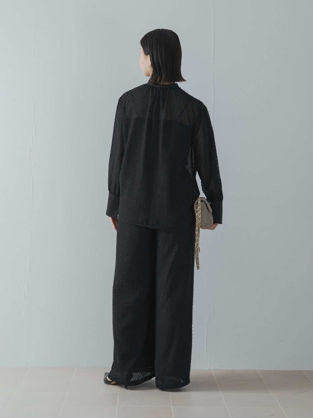 ブラック系のパンツドレスを着用したレディースの秋コーディネートの5枚目の写真