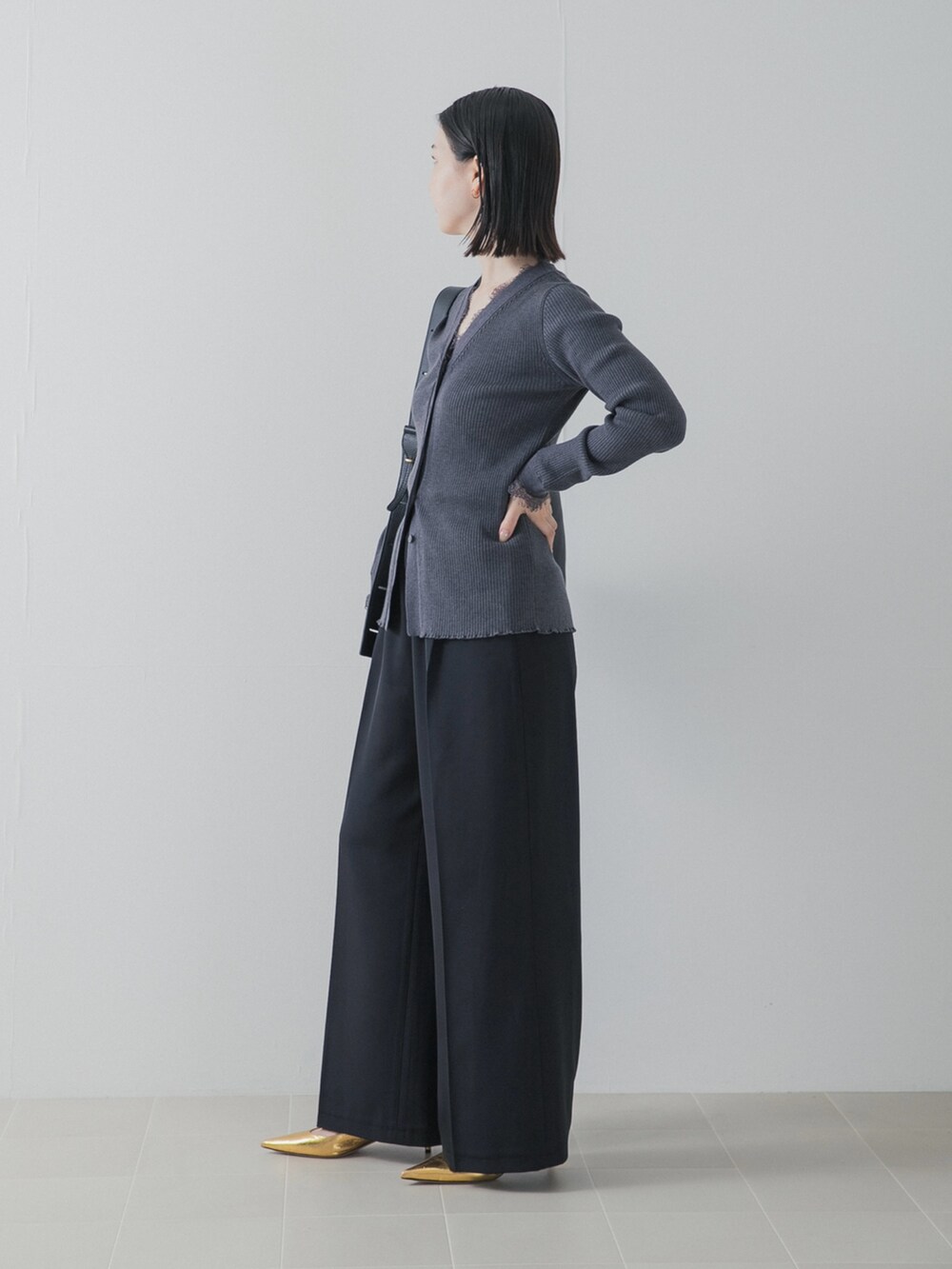 ブラック系のその他パンツ、ゴールド系のパンプス、グレー系のニット/セーターを着用したレディースの秋コーディネートの4枚目の写真