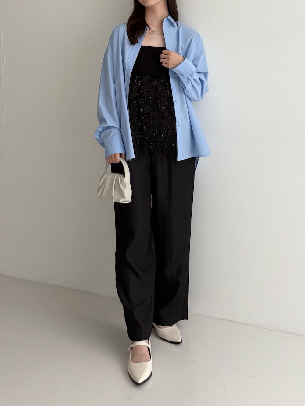 ブラック系のニット/セーター、ブラック系のその他パンツ、ホワイト系のハンドバッグを着用したレディースの秋コーディネートの2枚目の写真