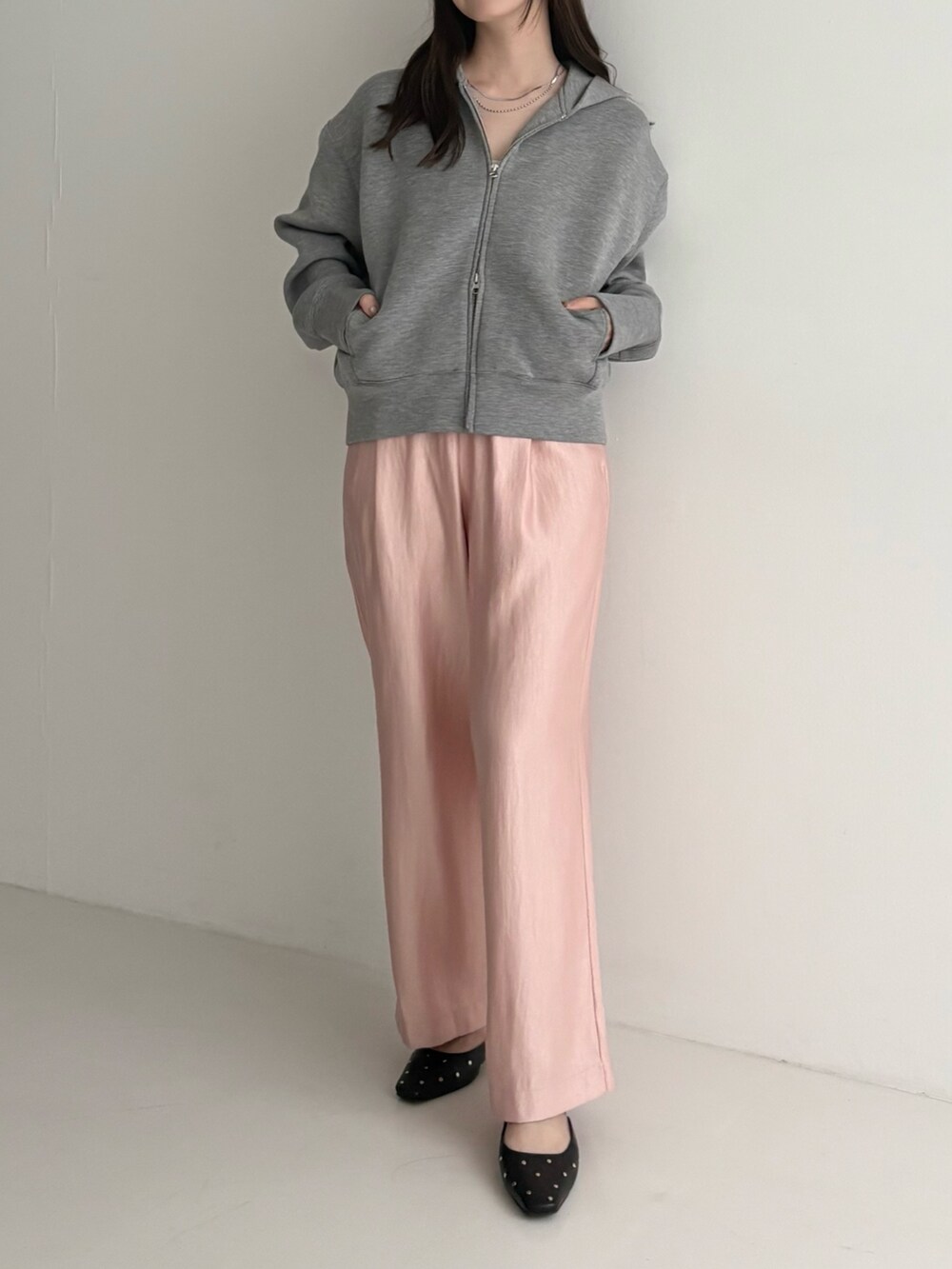 グレー系のパーカー、ピンク系のその他パンツを着用したレディースの秋コーディネートの2枚目の写真