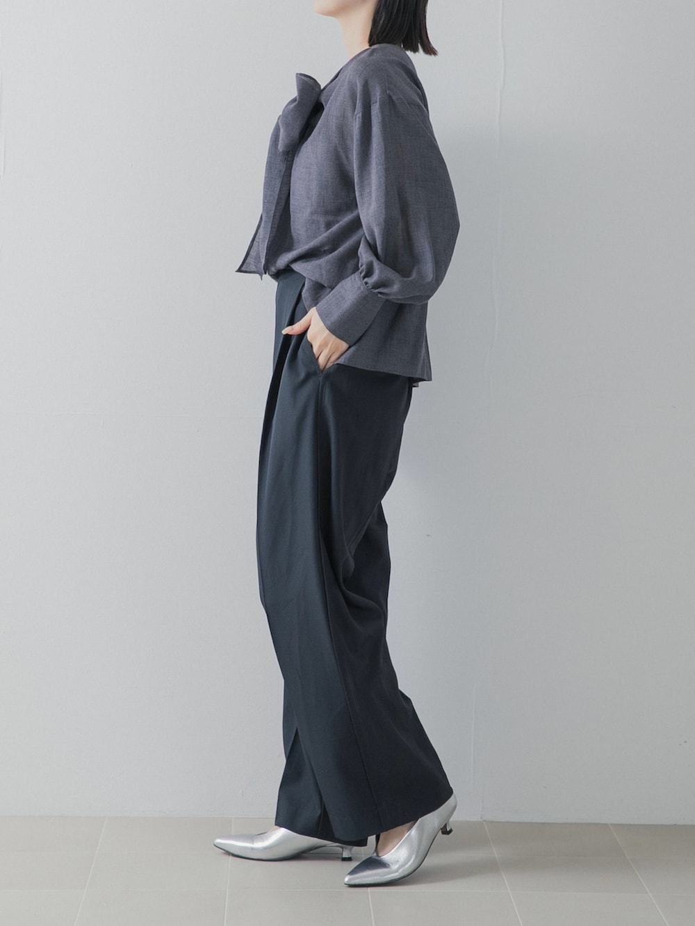 ブラック系のその他パンツ、グレー系のシャツ/ブラウス、シルバー系のパンプスを着用したレディースの秋コーディネートの4枚目の写真