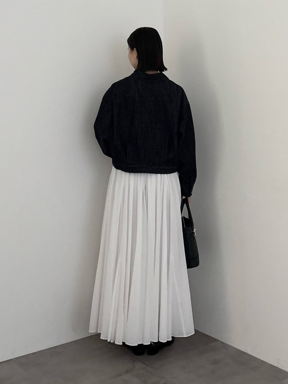 ブルー系のデニムジャケット、ホワイト系のスカートを着用したレディースの冬コーディネートの4枚目の写真