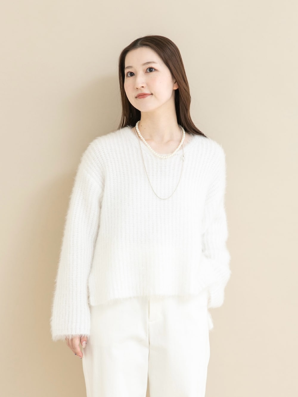 ホワイト系のニット/セーター、ホワイト系のデニムパンツを着用したレディースの冬コーディネートの4枚目の写真