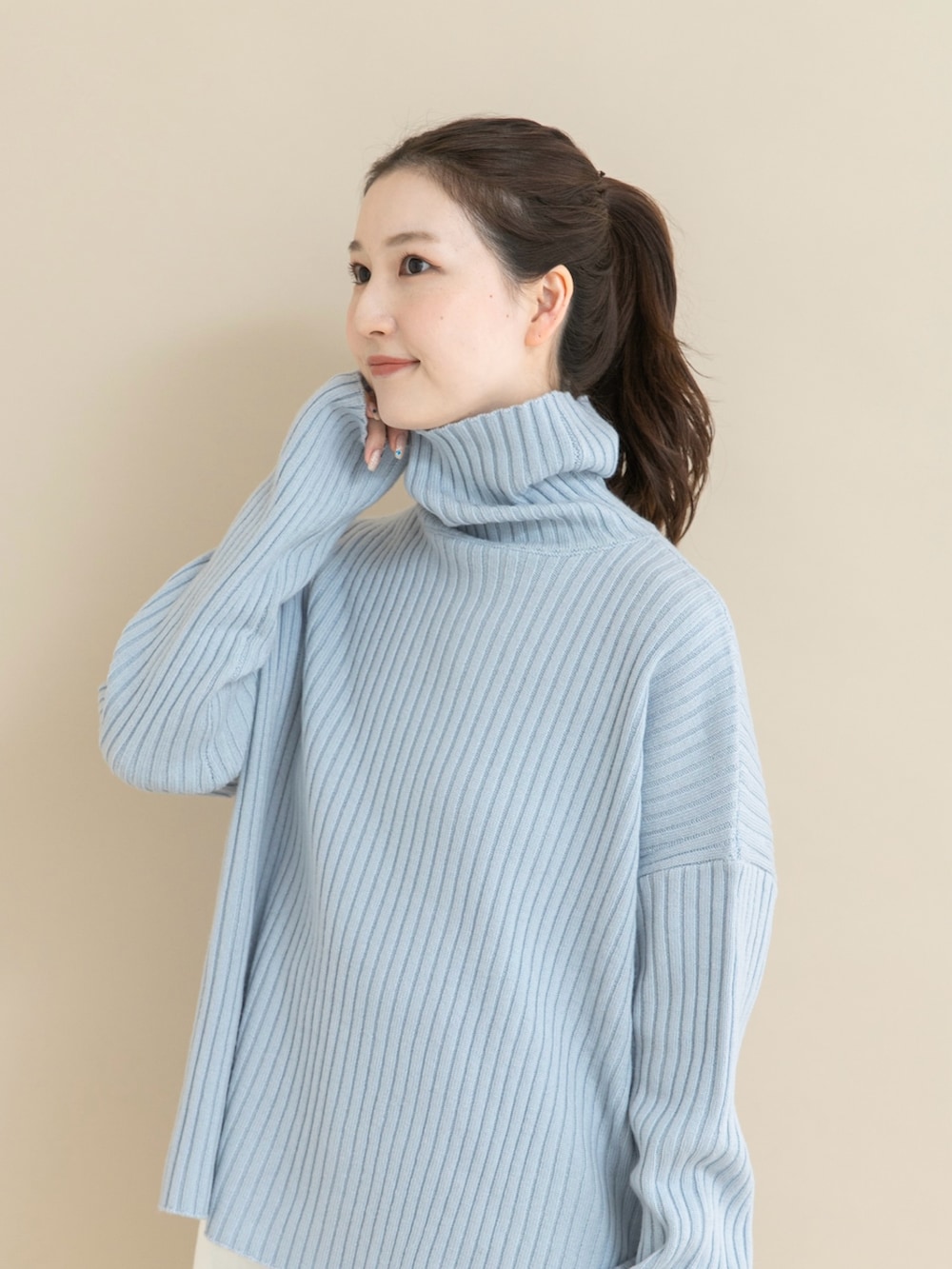 ブルー系のニット/セーター、ホワイト系のデニムパンツを着用したレディースの冬コーディネートの5枚目の写真