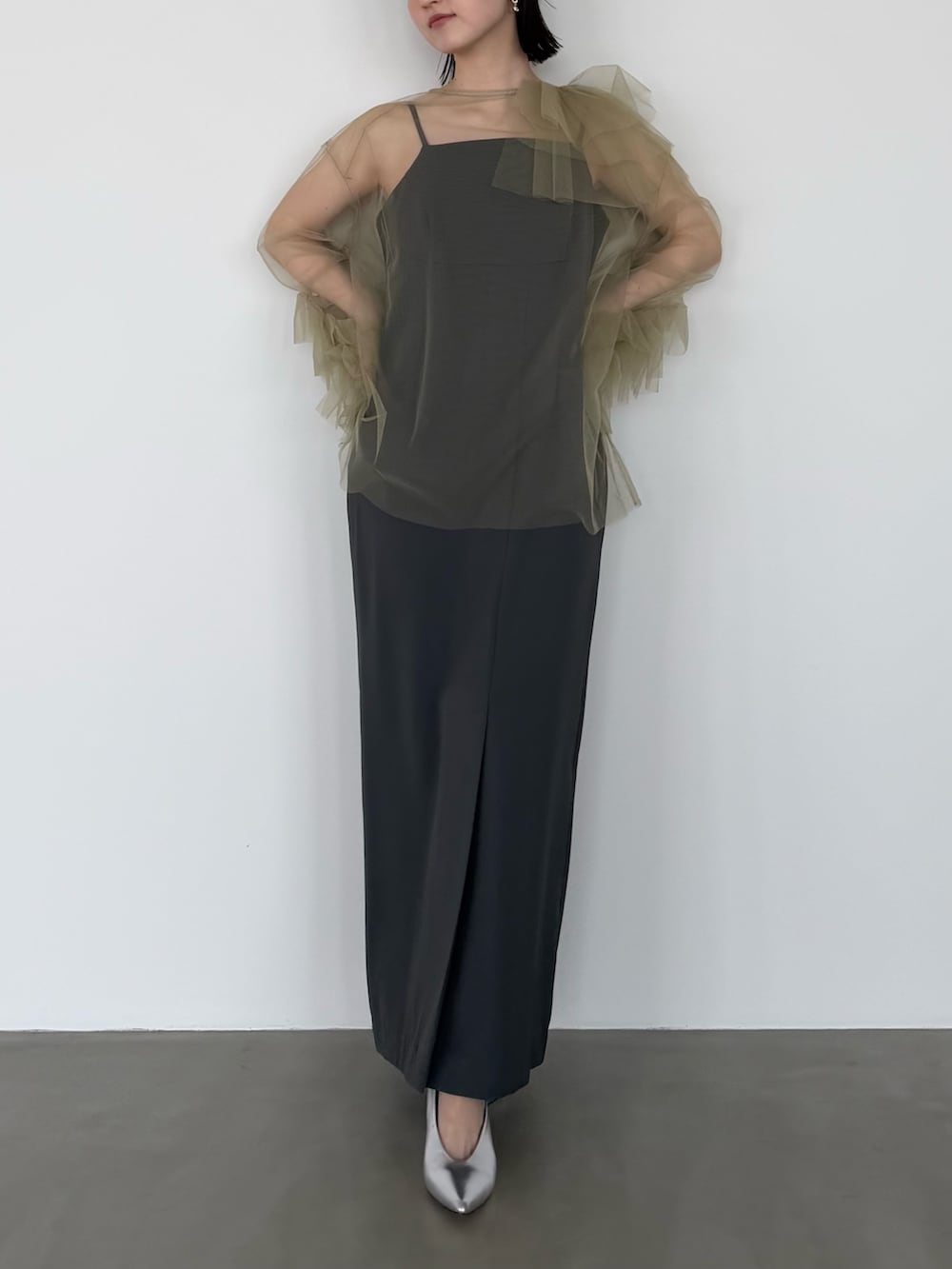 グリーン系のワンピース、シルバー系のパンプスを着用したレディースの春コーディネートの2枚目の写真