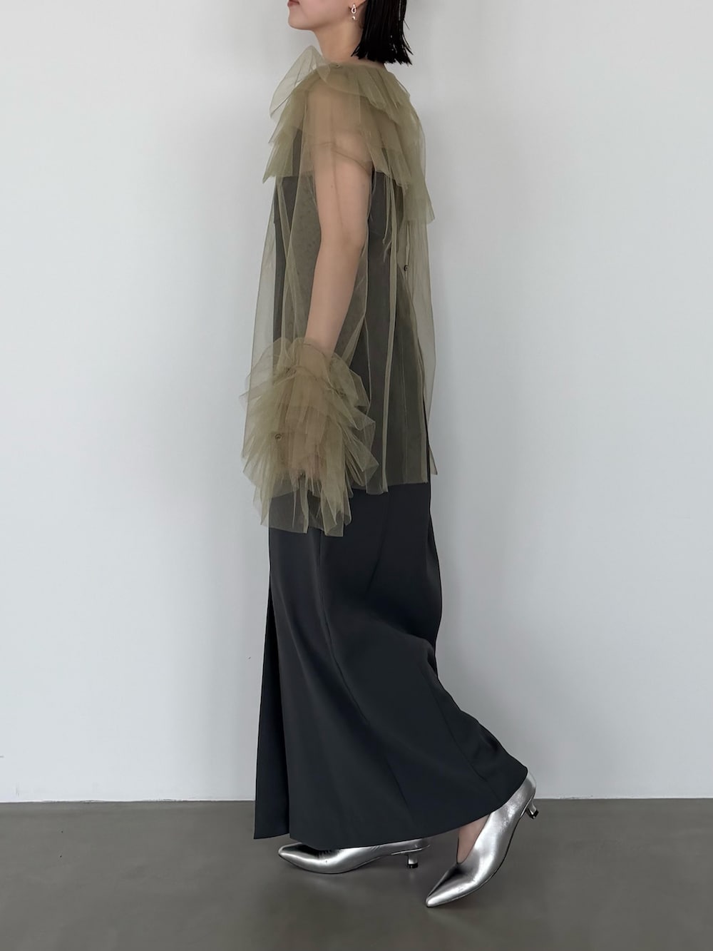 グリーン系のワンピース、シルバー系のパンプスを着用したレディースの春コーディネートの3枚目の写真