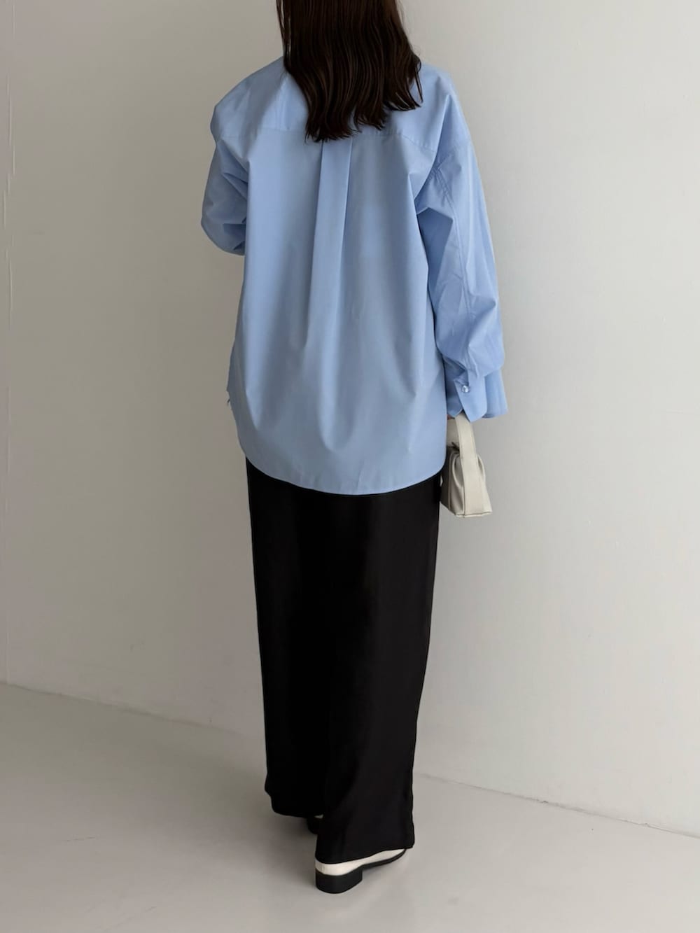 ブラック系のニット/セーター、ブラック系のその他パンツ、ホワイト系のハンドバッグを着用したレディースの秋コーディネートの3枚目の写真