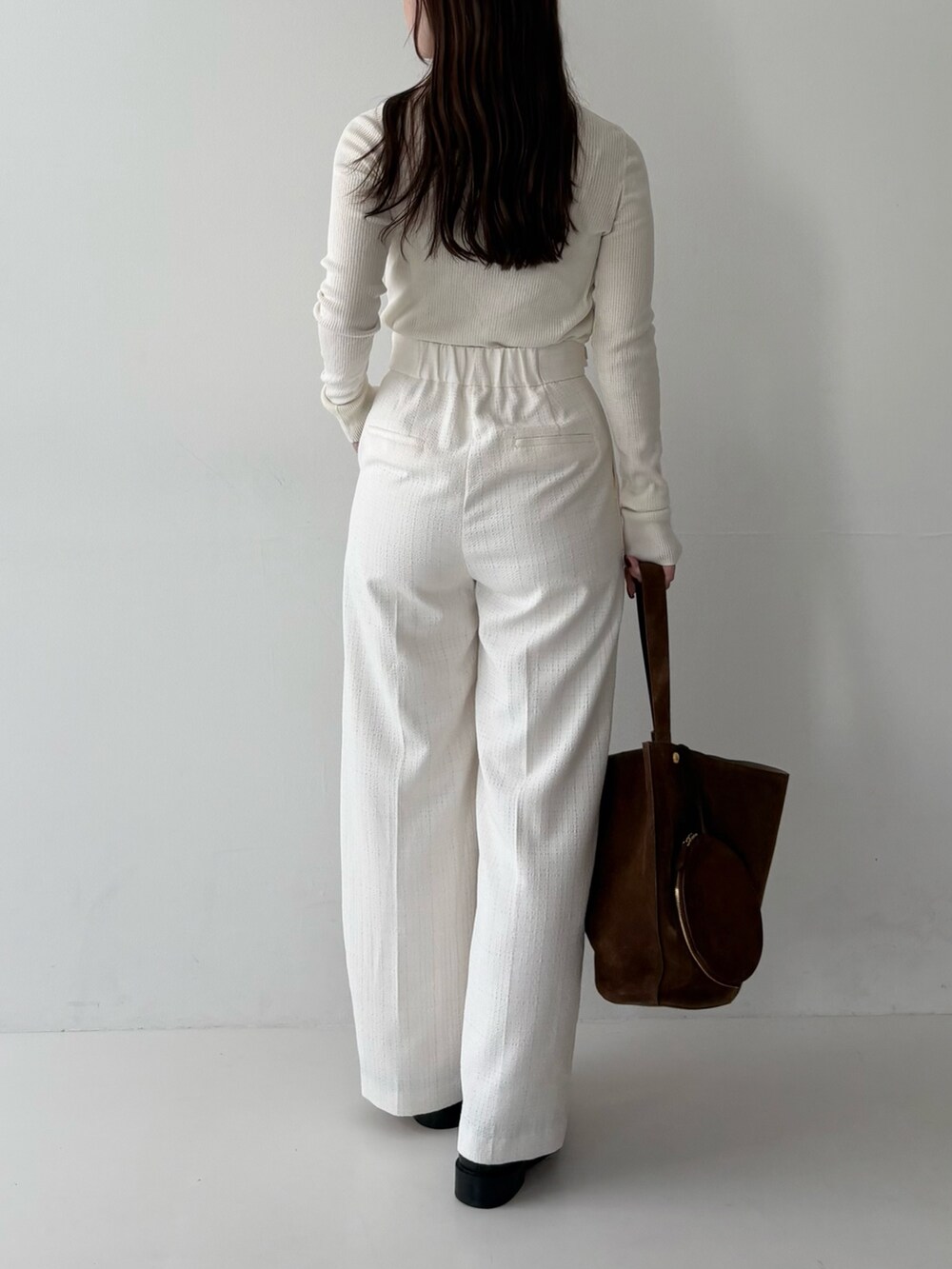 ホワイト系のニット/セーター、ホワイト系のその他パンツ、ブラウン系のトートバッグを着用したレディースの秋コーディネートの2枚目の写真