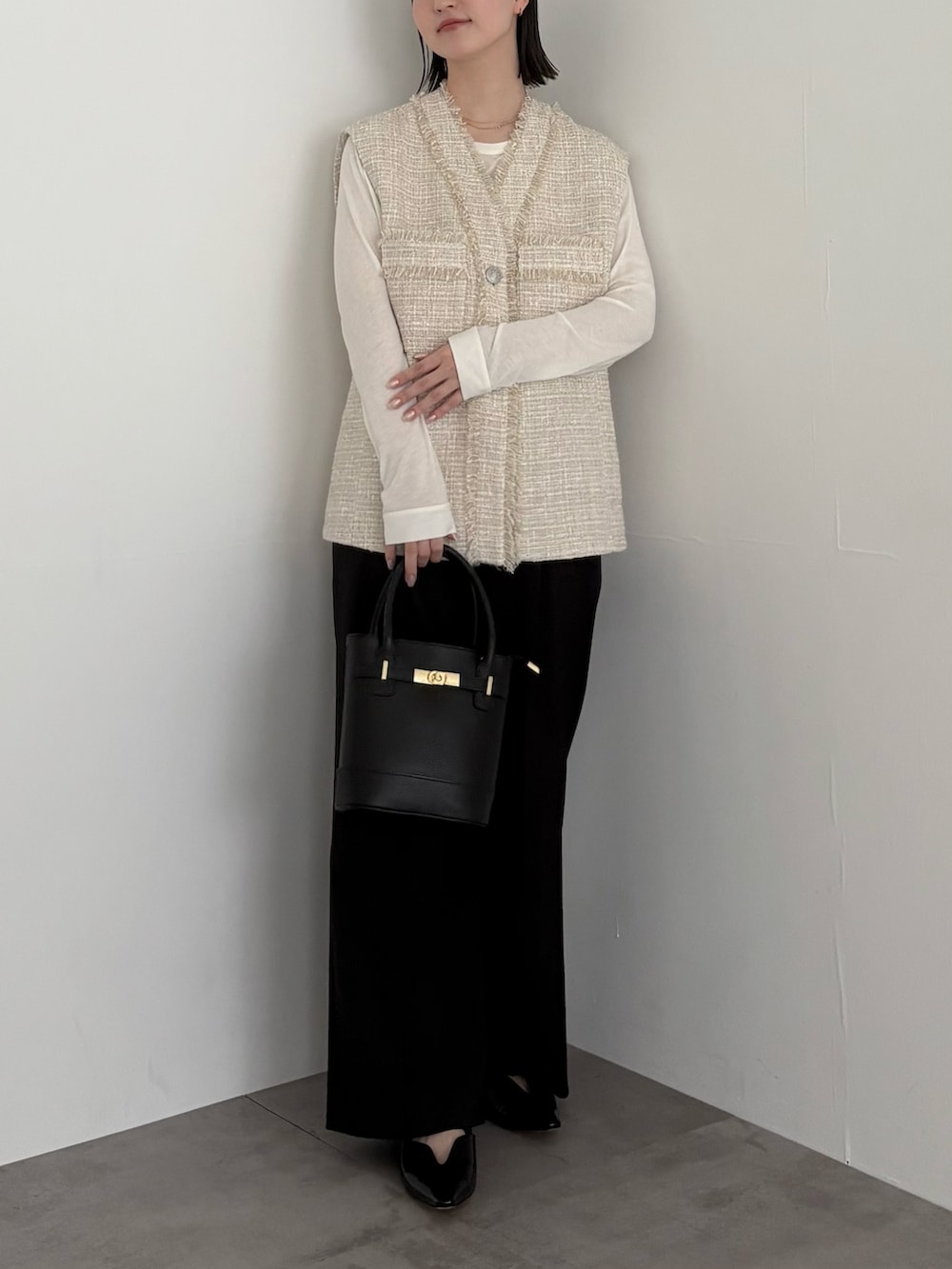 ベージュ系のベスト、ブラック系のその他パンツを着用したレディースの冬コーディネートの4枚目の写真