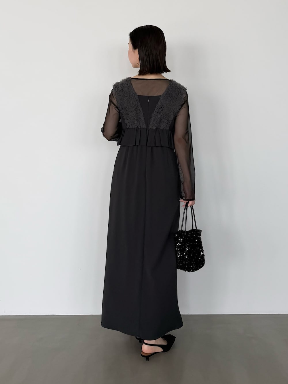 グレー系のワンピース、ブラック系のパンプスを着用したレディースの冬コーディネートの5枚目の写真