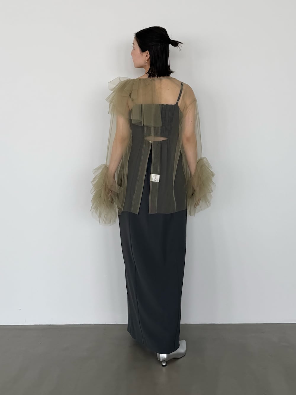 グリーン系のワンピース、シルバー系のパンプスを着用したレディースの春コーディネートの4枚目の写真