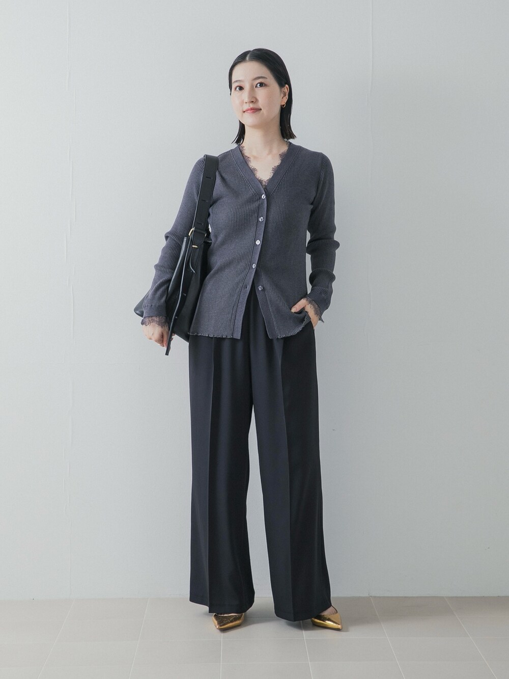 ブラック系のその他パンツ、ゴールド系のパンプス、グレー系のニット/セーターを着用したレディースの秋コーディネートの2枚目の写真