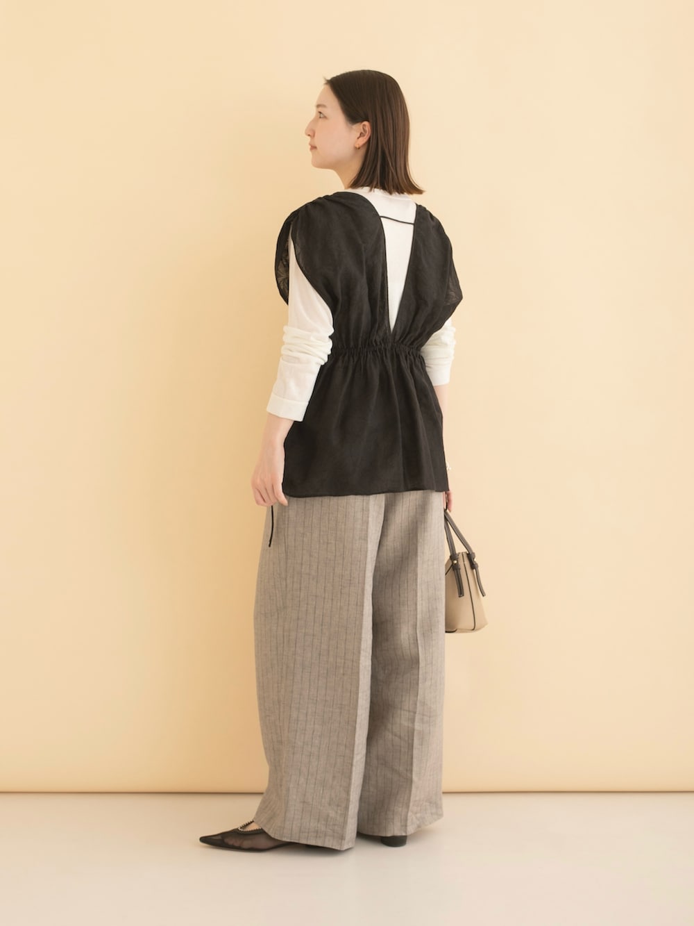 ブラック系のその他トップス、グレー系のその他パンツ、ホワイト系のTシャツ/カットソーを着用したレディースの冬コーディネートの5枚目の写真