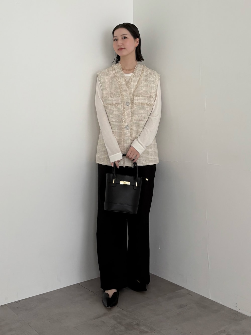 ベージュ系のベスト、ブラック系のその他パンツを着用したレディースの冬コーディネートの2枚目の写真