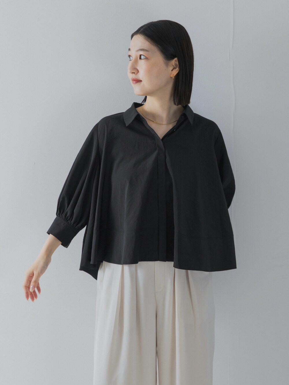 ブラック系のシャツ/ブラウス、ゴールド系のパンプスを着用したレディースの夏コーディネートの5枚目の写真