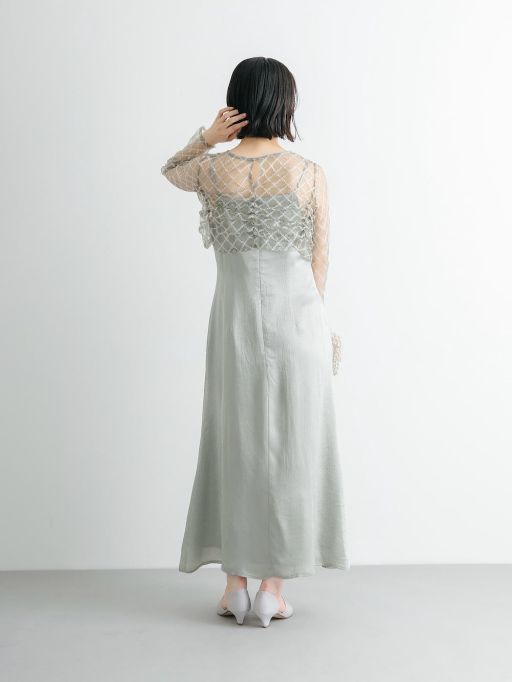 グレー系のパンプス、グリーン系のワンピースを着用したレディースの夏コーディネートの3枚目の写真