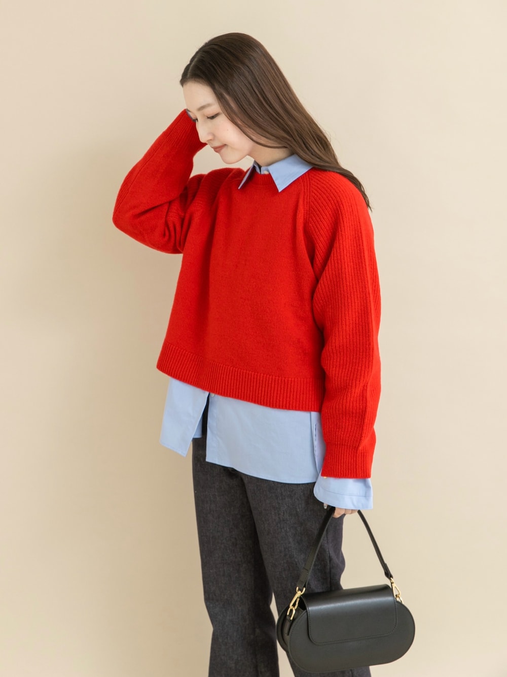 レッド系のニット/セーター、ブラック系のパンプスを着用したレディースの冬コーディネートの4枚目の写真