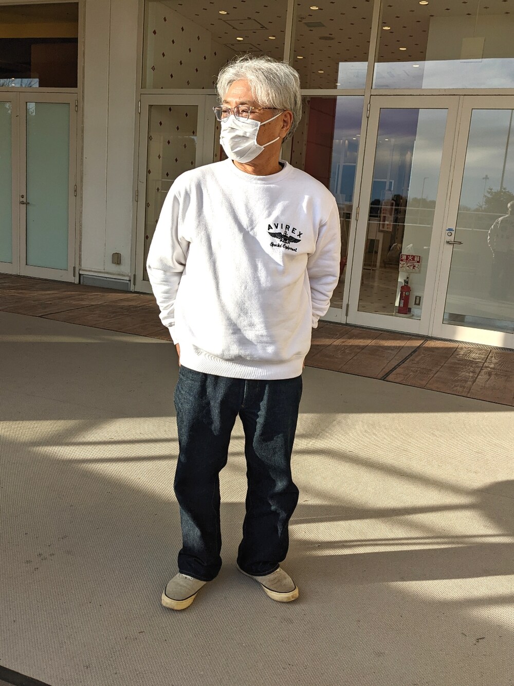 ホワイト系のスウェット、ブルー系のデニムパンツ、グレー系のスニーカーを着用したメンズの冬コーディネートの2枚目の写真