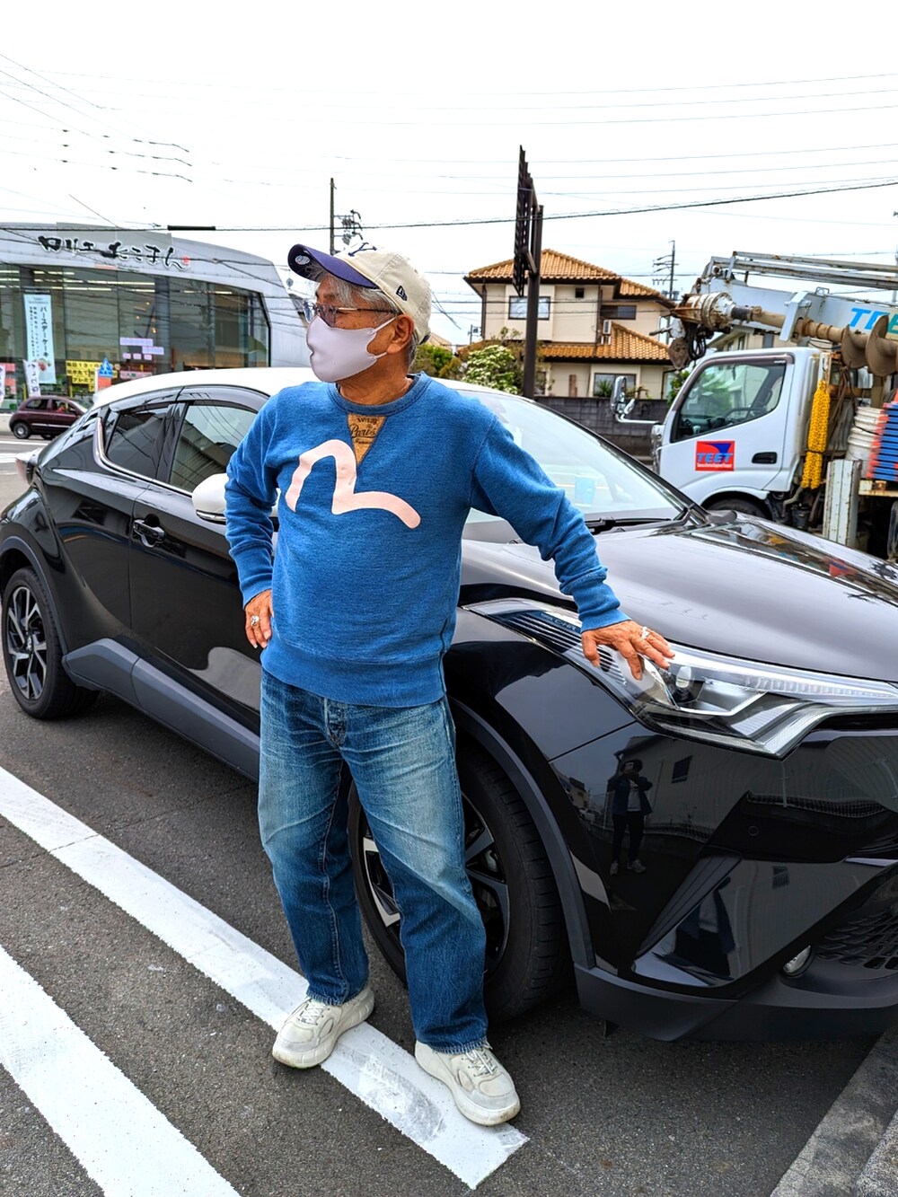 ブルー系のスウェット、ブルー系のデニムパンツ、ホワイト系のスニーカーを着用したメンズの春コーディネートの2枚目の写真