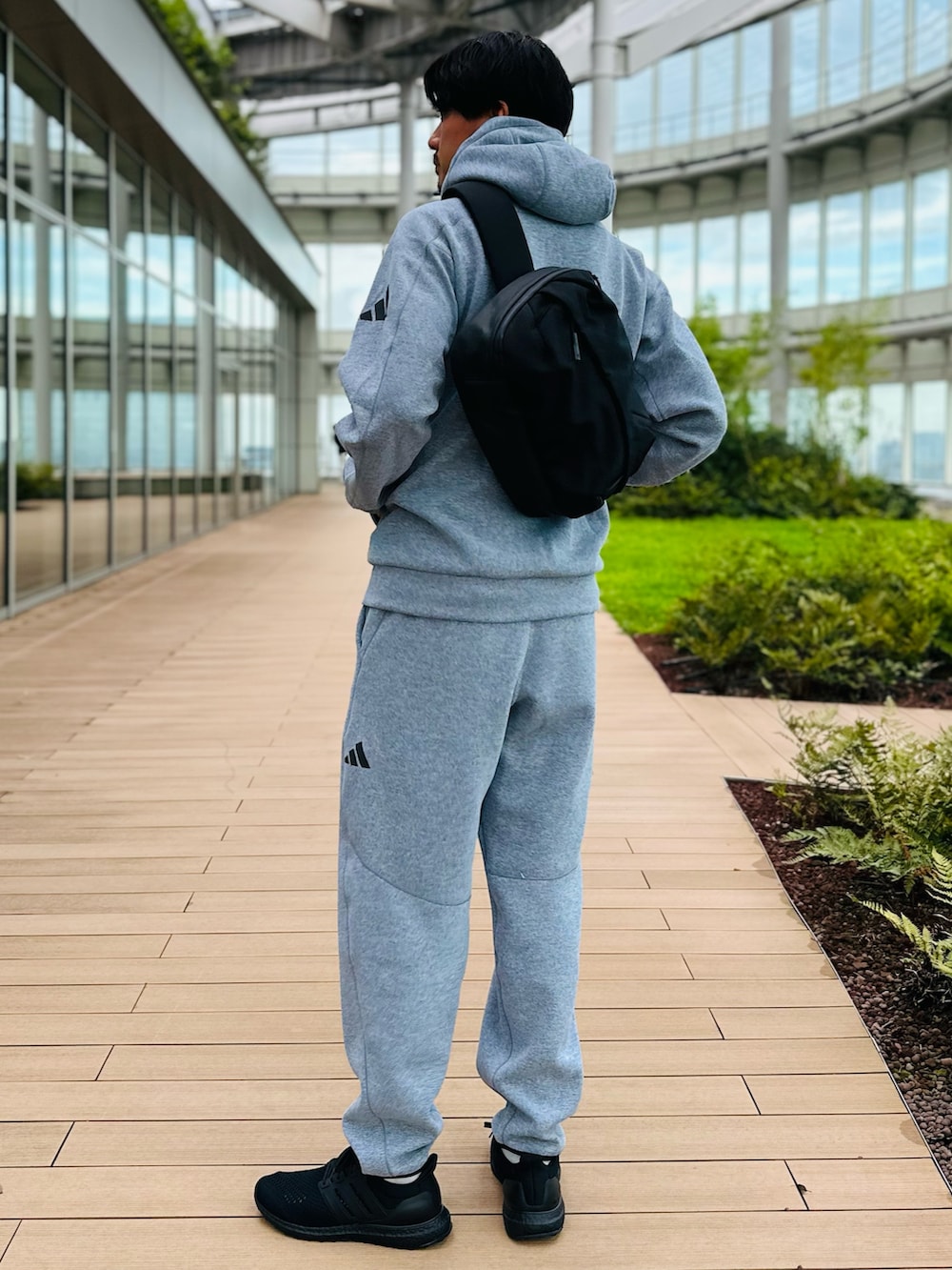 ブラック系のスニーカー、グレー系のその他パンツ、ブラック系のショルダーバッグを着用したメンズの夏コーディネートの2枚目の写真