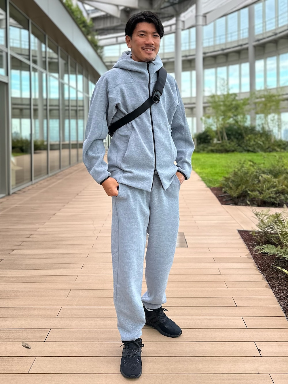 ブラック系のスニーカー、グレー系のその他パンツ、ブラック系のショルダーバッグを着用したメンズの夏コーディネートの3枚目の写真