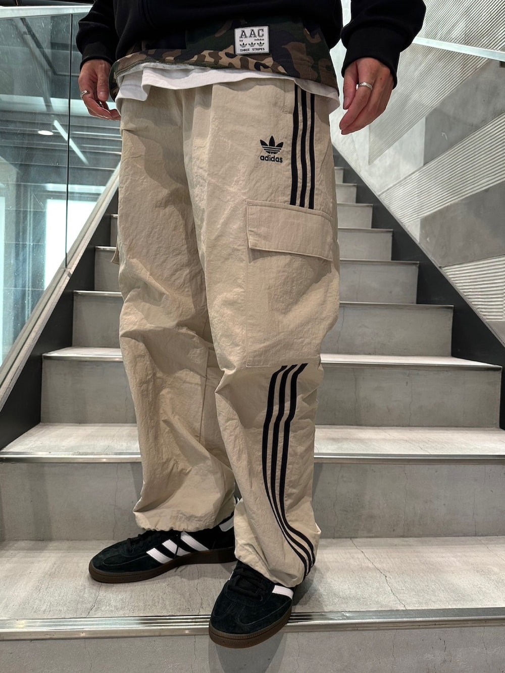 グリーン系のTシャツ/カットソー、ブラック系のジャージ、ブラック系のカーゴパンツを着用したメンズの夏コーディネートの4枚目の写真