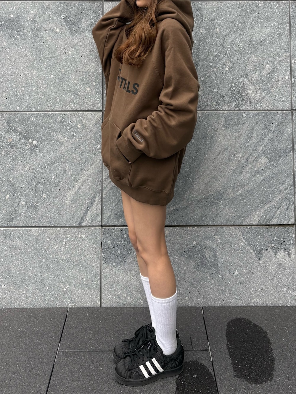 ブラウン系のパーカー、グレー系のその他パンツ、ブラック系のスニーカーを着用したレディースの春コーディネートの2枚目の写真