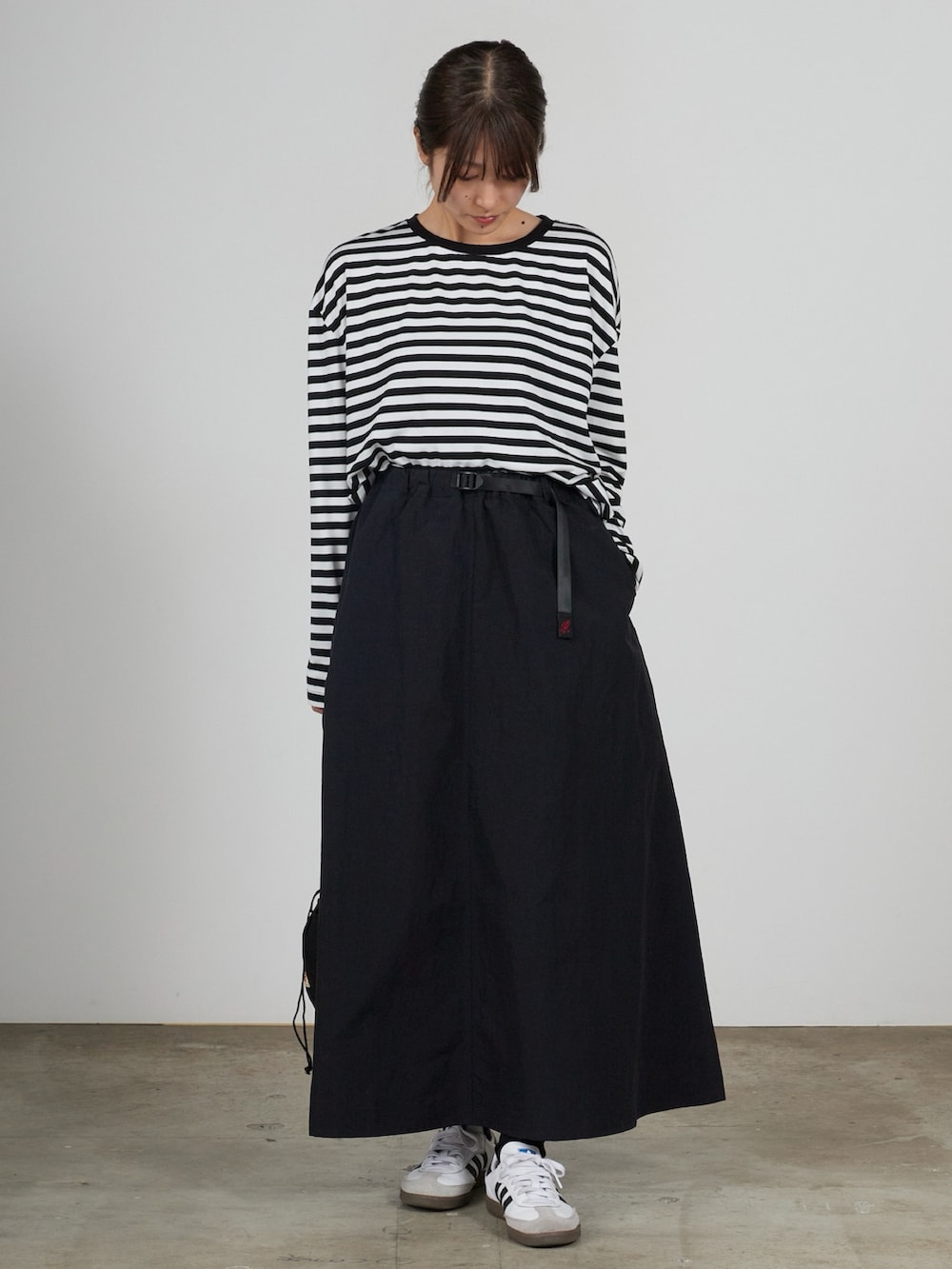 ブラック系のスカートを着用したレディースの春コーディネートの2枚目の写真