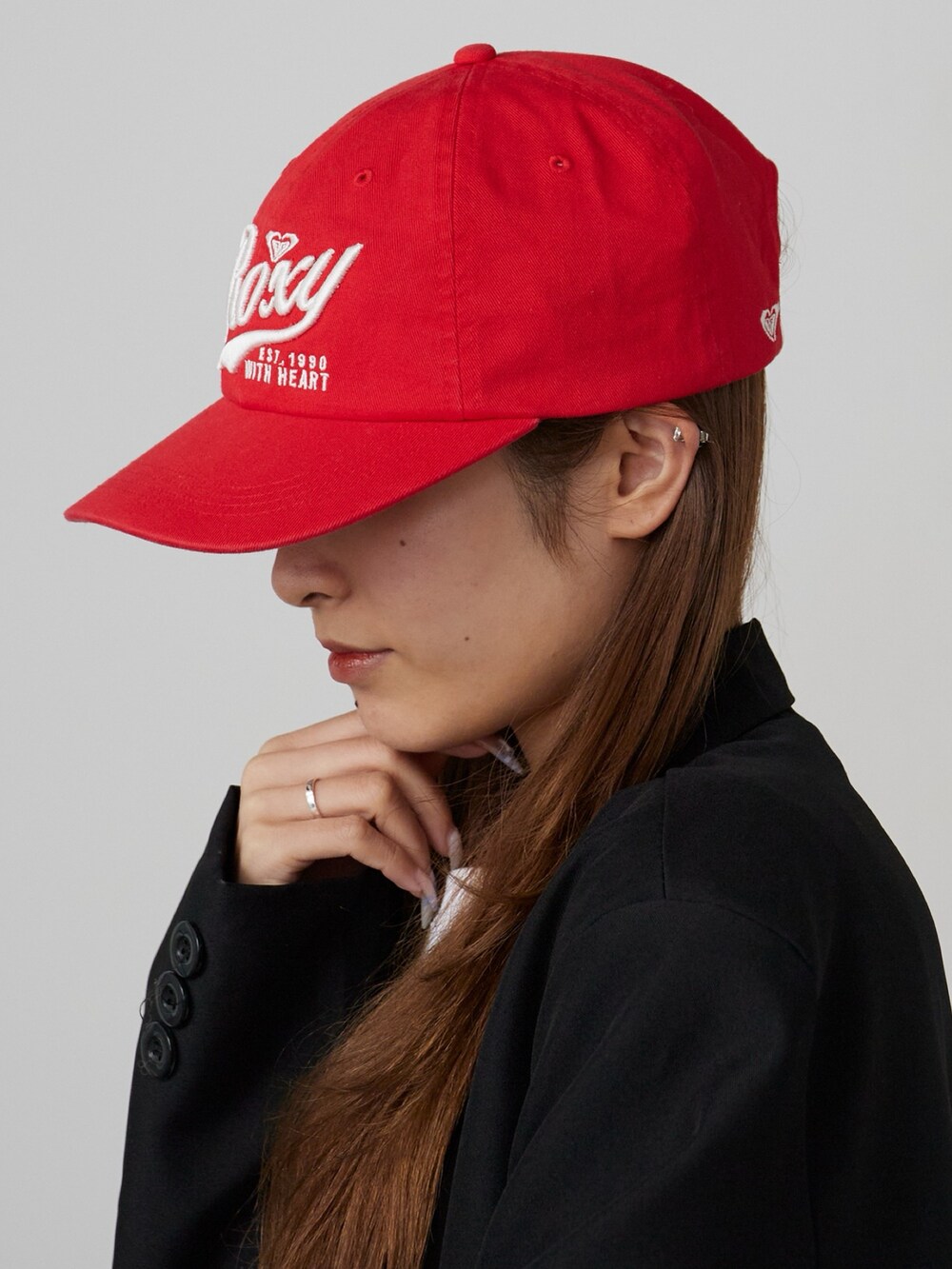 レッド系のキャップを着用したレディースの春コーディネートの2枚目の写真