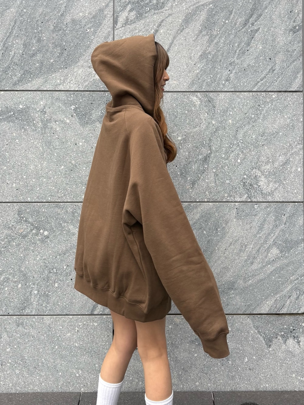 ブラウン系のパーカー、グレー系のその他パンツ、ブラック系のスニーカーを着用したレディースの春コーディネートの3枚目の写真