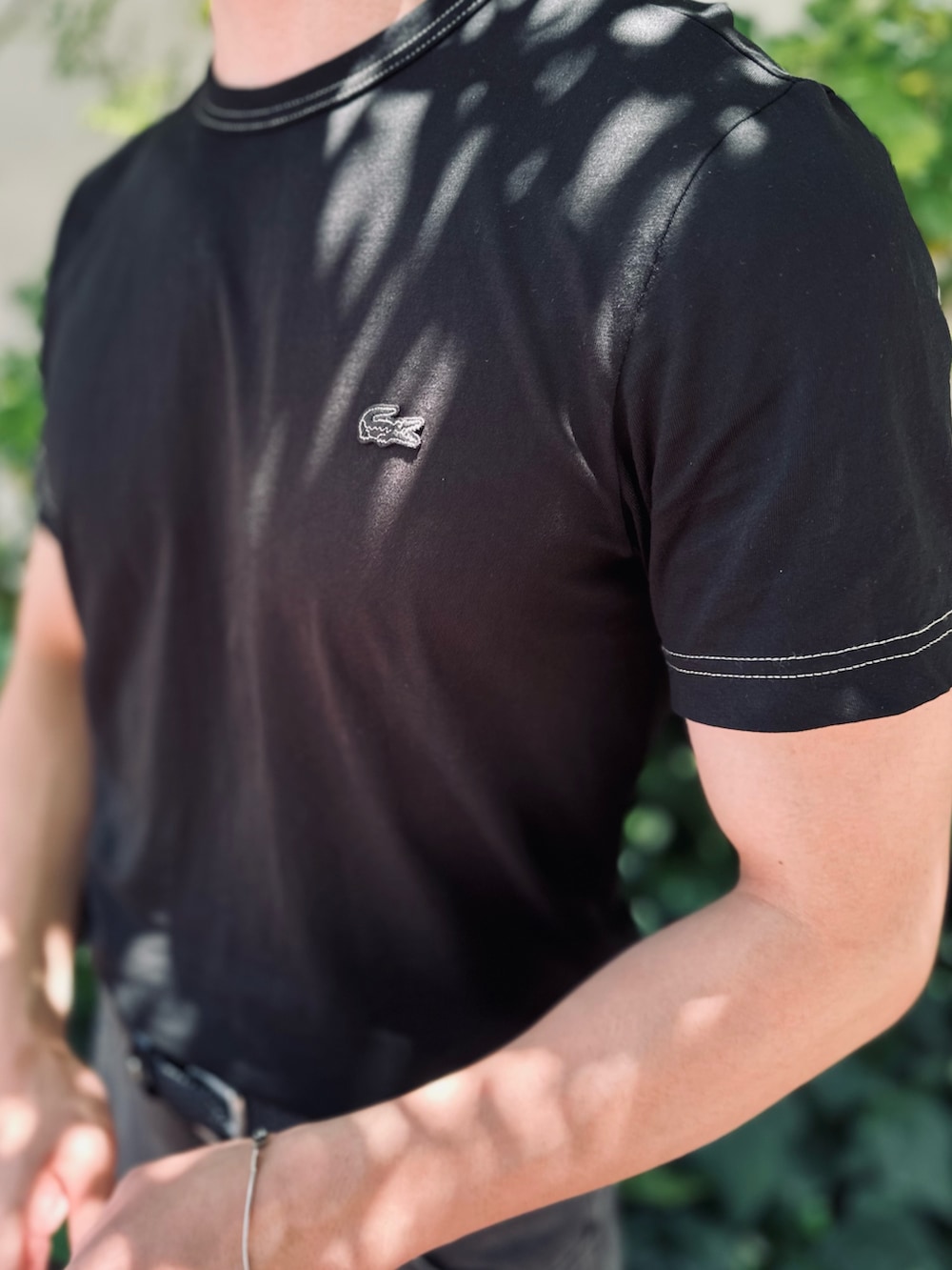 ブラック系のTシャツ/カットソー、ブラック系のデニムパンツ、ブラック系のクラッチバッグを着用したメンズの夏コーディネートの6枚目の写真