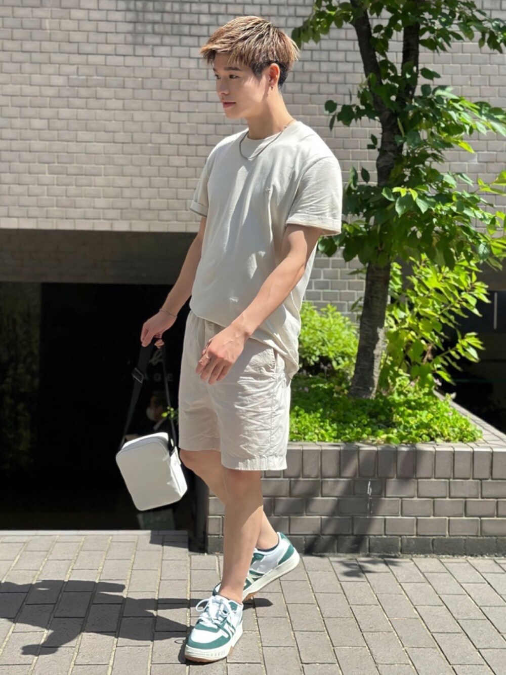 ベージュ系のTシャツ/カットソー、ベージュ系のその他パンツ、ホワイト系のショルダーバッグを着用したメンズの春コーディネートの3枚目の写真