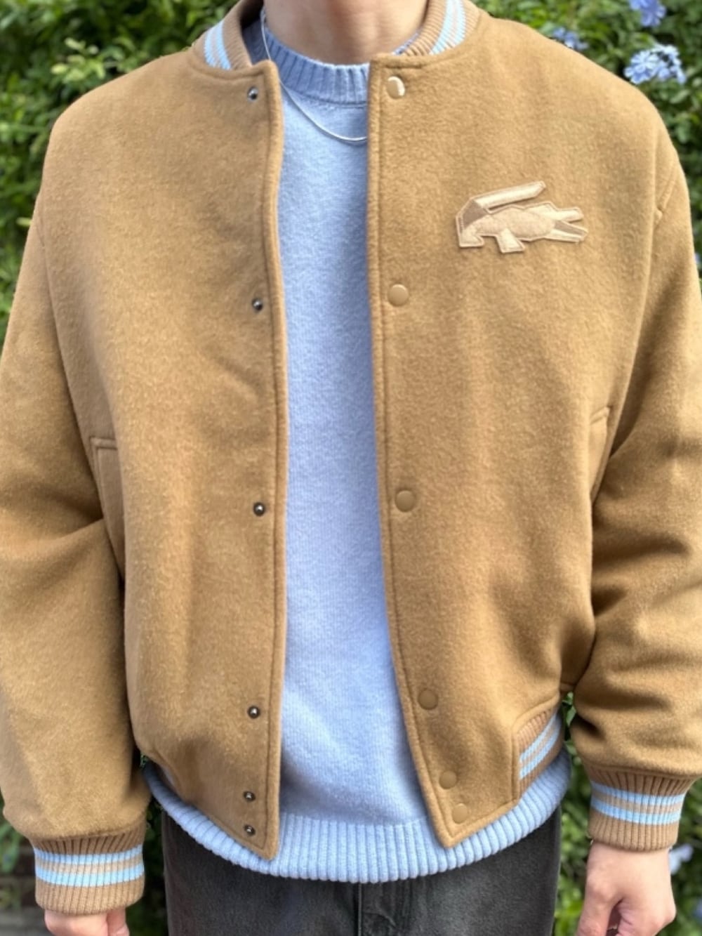 ブラウン系のブルゾン、ブルー系のニット/セーター、ブラック系のデニムパンツを着用したメンズの春コーディネートの6枚目の写真