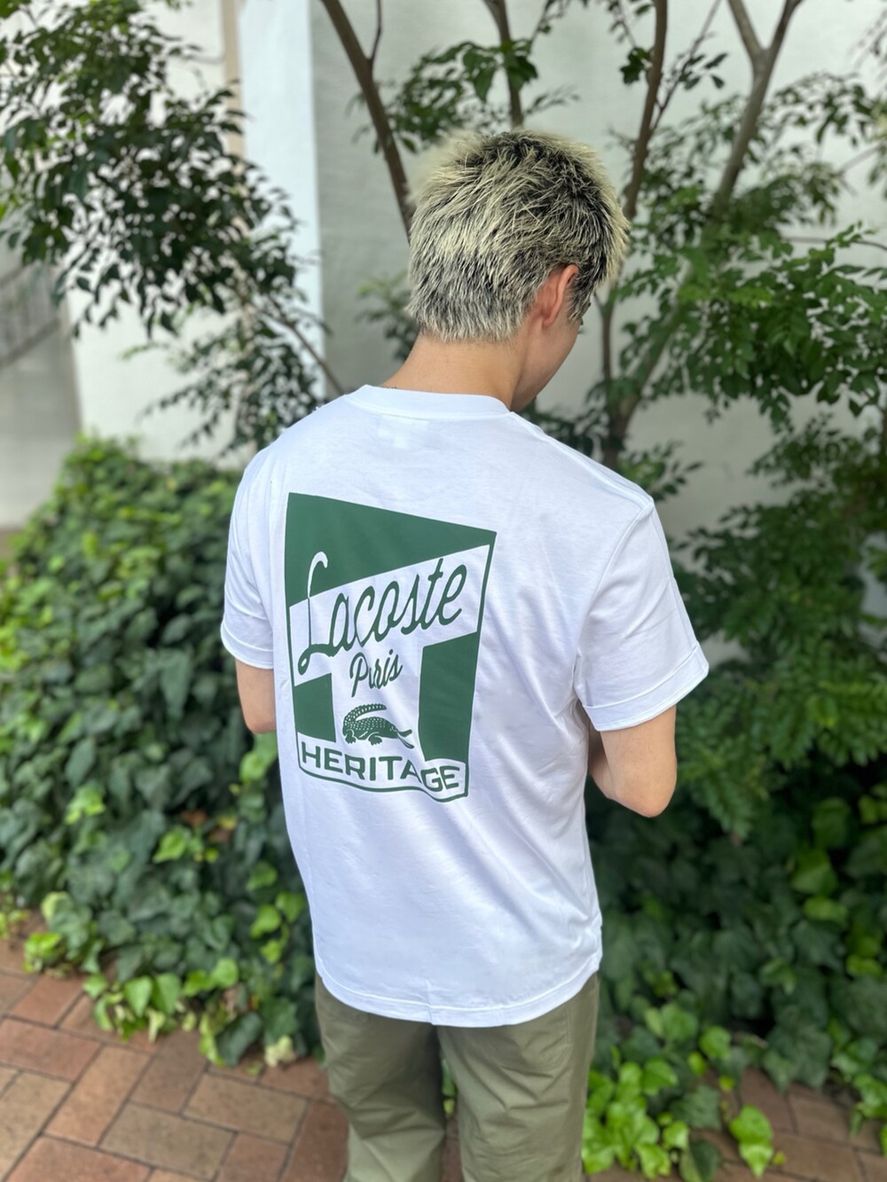 ホワイト系のTシャツ/カットソー、グリーン系のショルダーバッグ、ホワイト系のスニーカーを着用したメンズの秋コーディネートの4枚目の写真