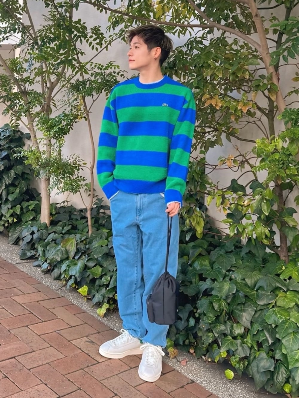ブルー系のニット/セーター、グレー系のデニムパンツ、ホワイト系のスニーカーを着用したメンズの春コーディネートの2枚目の写真