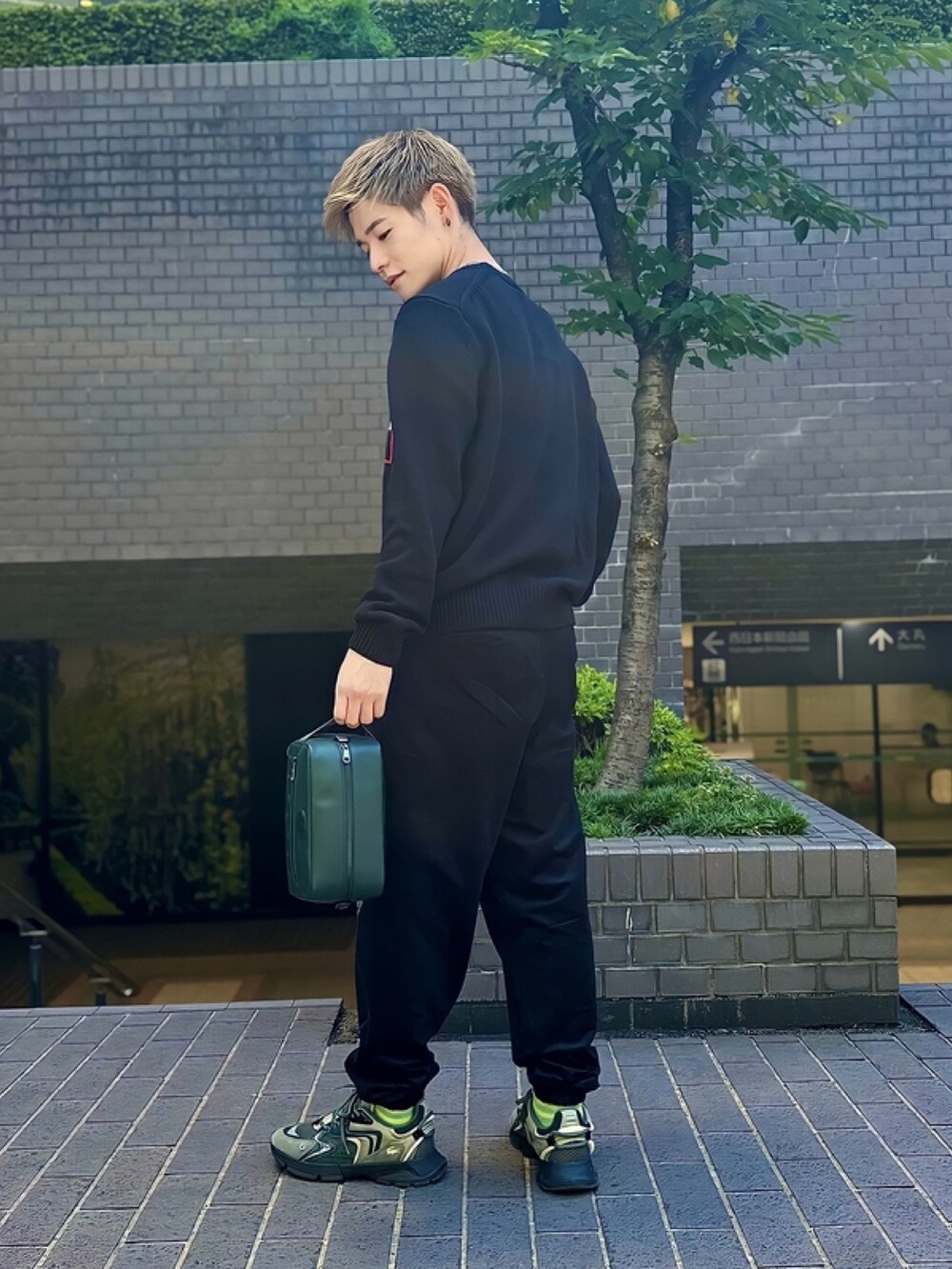 ブラック系のニット/セーター、ブラック系のその他パンツ、グリーン系のショルダーバッグを着用したメンズの春コーディネートの4枚目の写真