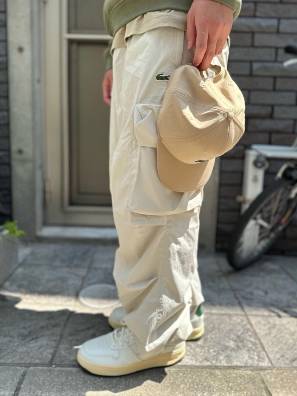 ホワイト系のカーゴパンツ、ホワイト系のスニーカー、ベージュ系のTシャツ/カットソーを着用したメンズの春コーディネートの5枚目の写真